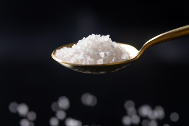 用勺子盛放食盐特写黑色背景