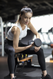 年轻女士在健身房举哑铃