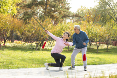 快乐的老年人在公园舞剑