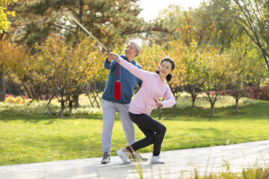 快乐的老年人在公园舞剑