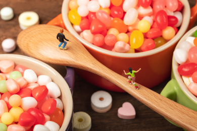 微缩创意木桌上的糖果碗与木勺上轮滑青少年