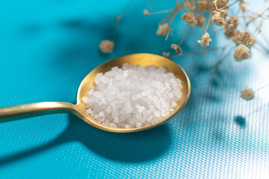 一勺食盐摆放在蓝色背景上