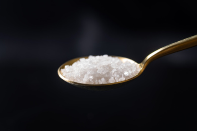 用勺子盛放食盐特写黑色背景