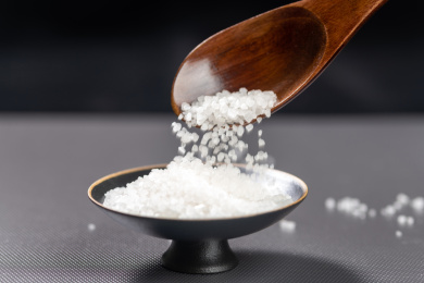 用勺子盛放食盐特写黑色背景