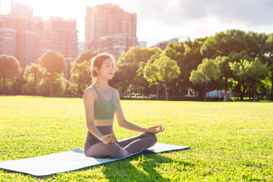 年轻女性在草坪上做瑜伽运动
