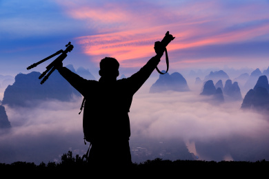 日出时成功登顶欣赏大自然的摄影师