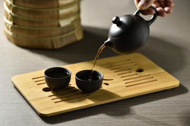 用紫砂壶向茶杯倒普洱熟茶汤