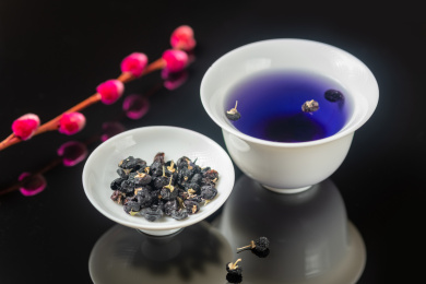 黑枸杞与黑枸杞茶摆放在黑色背景上