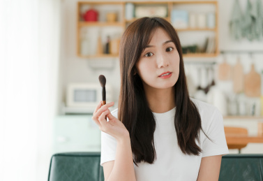 美女手拿化妆刷在家化妆