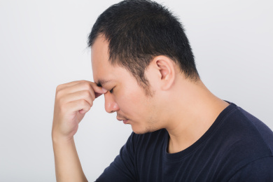 低头皱眉的亚洲男人