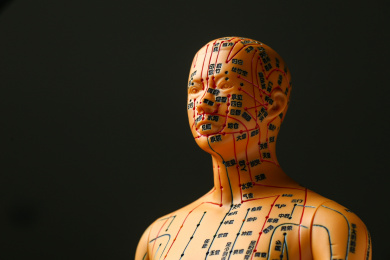 中医针灸模型特写在黑色背景前