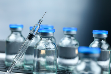 疫苗玻璃注射器和放在笔记本电脑键盘背景上