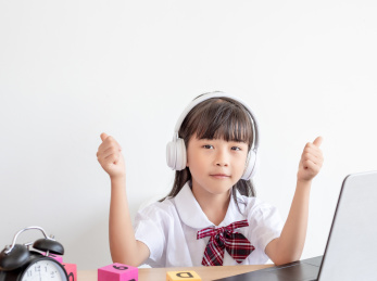 小学生在家使用手提电脑上网课