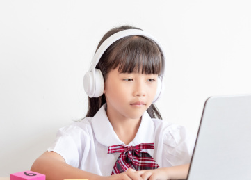 小学生在家使用手提电脑上网课