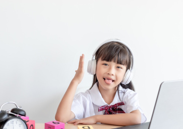 小学生在家使用手提电脑上网课