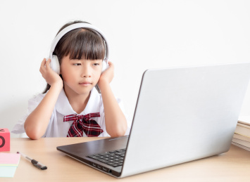 小学生在家使用手提电脑上网课
