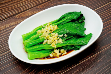 木桌背景的一盘广东白灼菜心