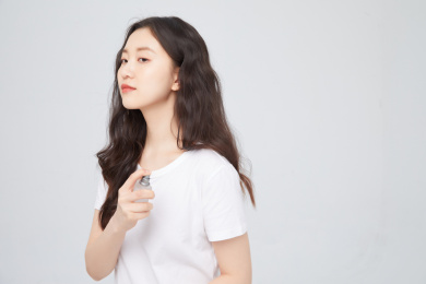 手拿香水的年轻女性