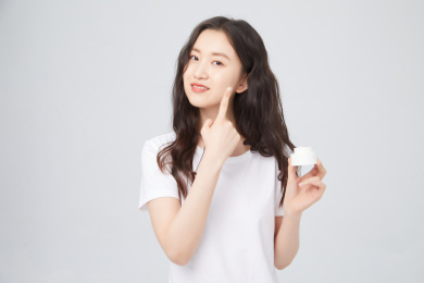 手拿护肤品的年轻女孩