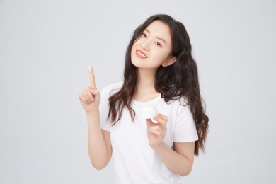 手拿护肤品的年轻女孩