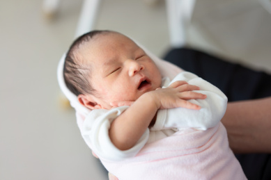 襁褓中拥抱自己入睡的婴儿