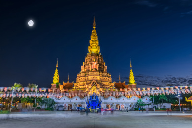 云南省景洪市夜晚月亮光照告庄大金塔建筑