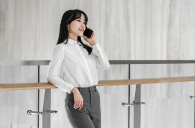 商务女性靠着栏杆用手机打电话