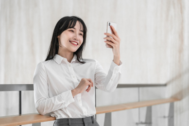 商务女性靠着栏杆用手机自拍