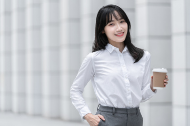 商务女性手拿纸杯在室外