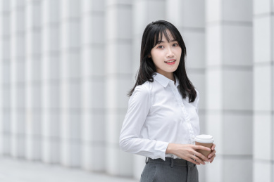 商务女性手拿纸杯在室外
