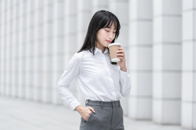 商务女性手拿纸杯在室外