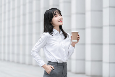 商务女性手拿纸杯在室外