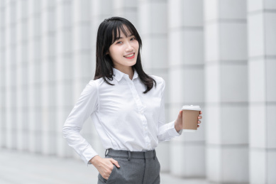 商务女性手拿纸杯在室外
