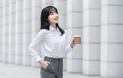 商务女性手拿纸杯在室外