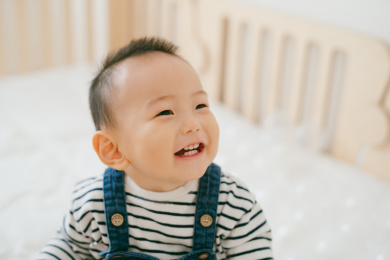 穿着条纹上衣牛仔背带裤的宝宝在开心的笑