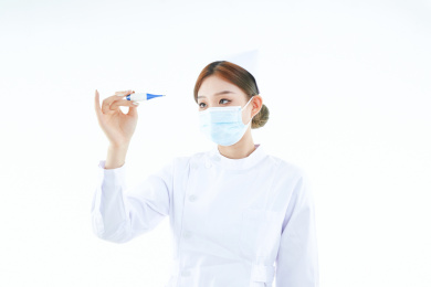 手持温度计的白衣女性医护人员