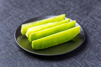 一盘青萝卜切片摆放在黑色背景上