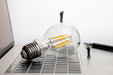 站在灯泡和电脑上思考的人