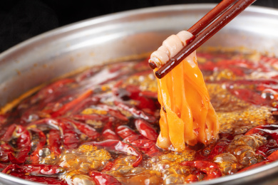 筷子夹着正在沸腾老火锅汤里烫火锅鲜鸭肠