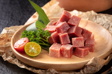 牛皮纸上木盘里的烤肉料理生切和牛牛肉粒
