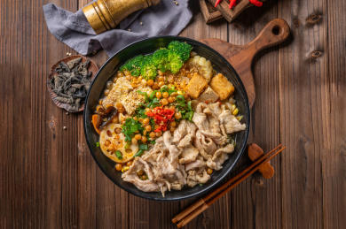 木纹桌上的一碗水煮肉片冒菜