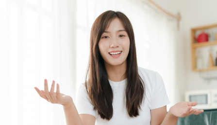 长发美女坐在家里双手摊开做手势