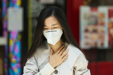 戴口罩咳嗽的女性