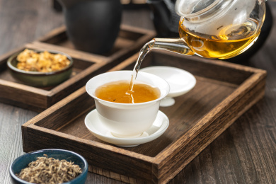 手持茶壶向盖碗中倒茶特写深色调