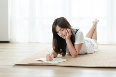 女生趴着地板上写字