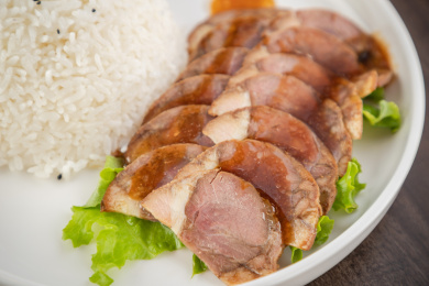 棕色木纹桌上放着一碗肘花盖饭