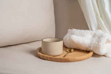 米色沙发上的一杯红茶和毛绒手套