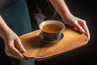 女性双手端着放有盖碗茶的茶盘上茶特写