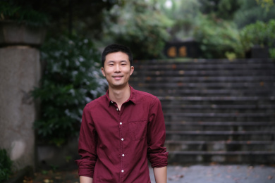 年轻帅气的中国男子对着镜头笑在户外的公园