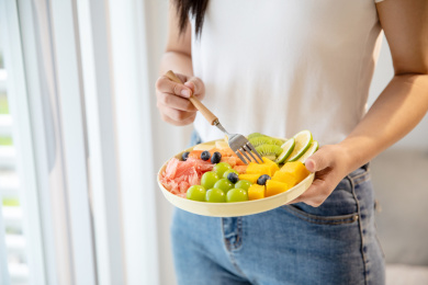 年轻女生手拿一盘水果沙拉